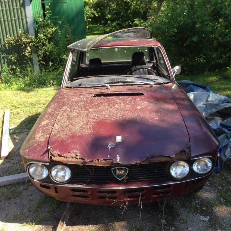 Willkommen in der Schreibwerkstatt Ein kaputtes rotes Auto steht verrottend auf einem Hinterhof